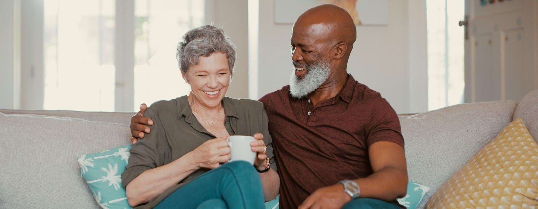 smiling, older couple, sit together on a couch